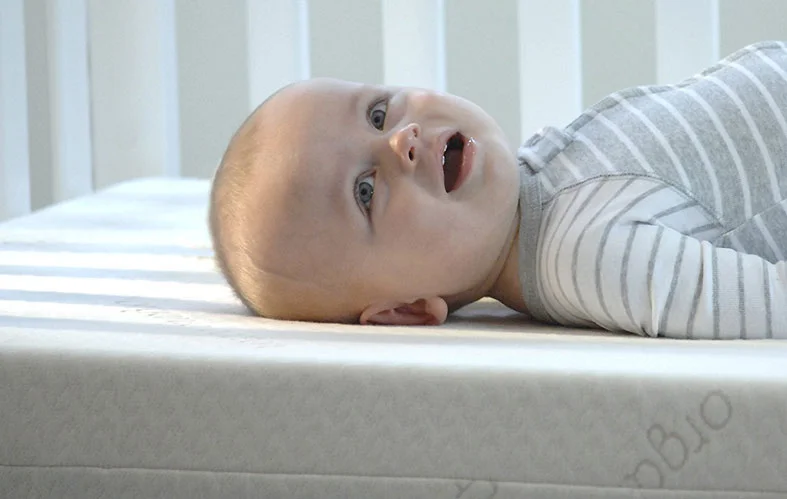 Find Out How Long Crib Mattresses Are Good For 2 happy baby on waterproof mattress