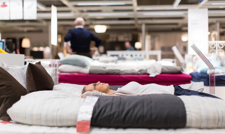 woman trying mattress in store