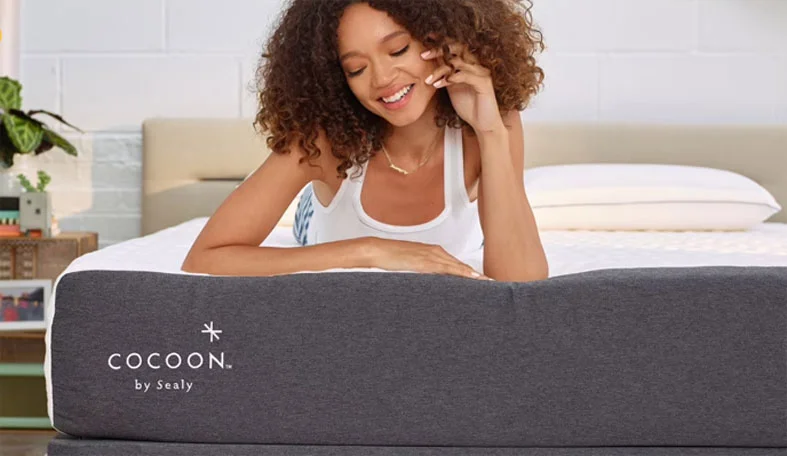 The Cocoon Chill by Sealy Mattress Review updated for 2026 5 happy woman is lying on her stomach on a cocoon chill bed