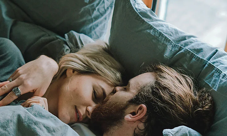 couple is laying in the bed