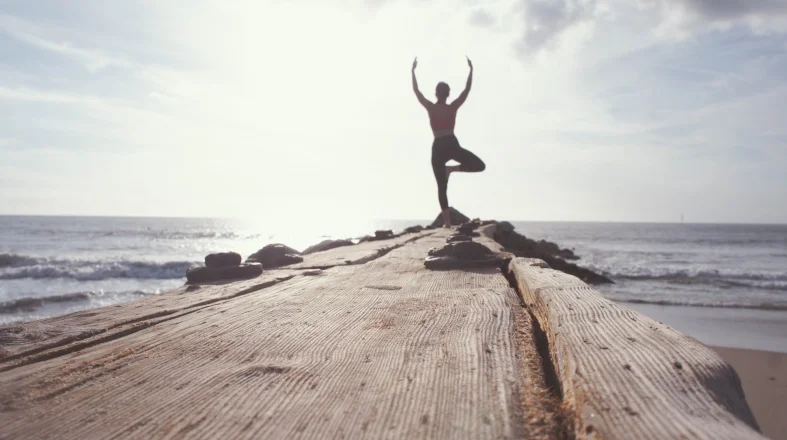 woman is doing yoga on the shore