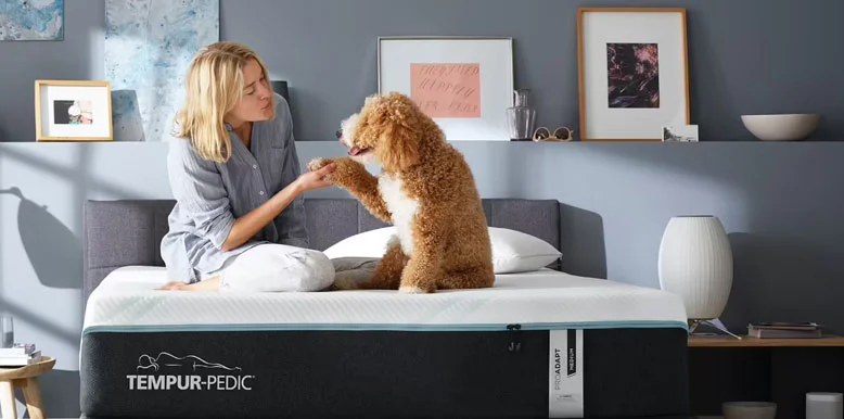 Tempur-Pedic TEMPUR-LuxeAdapt® Mattress Review for 2026, Expert Tested 6 a lady and a dog are sitting on the tempur-adapt bed